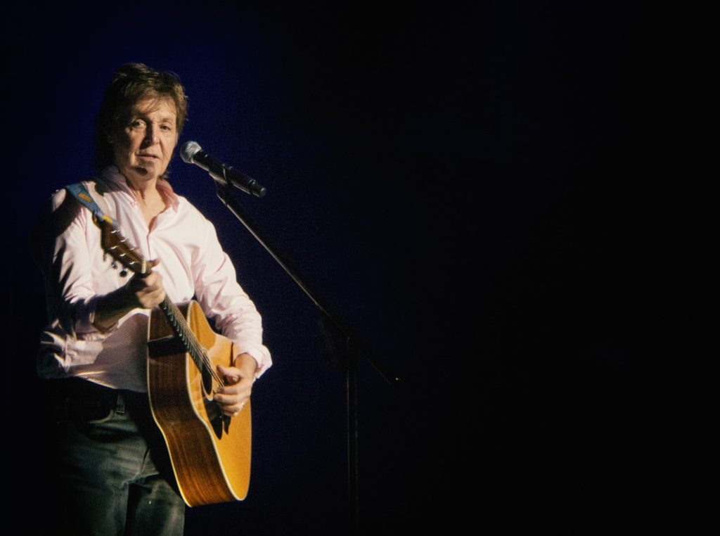 Paul McCartney in Dusseldorf in 2016, playing an acoustic guitar.